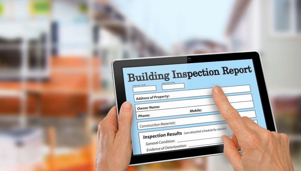 building,inspector,completing,an,inspection,form,on,computer,tablet